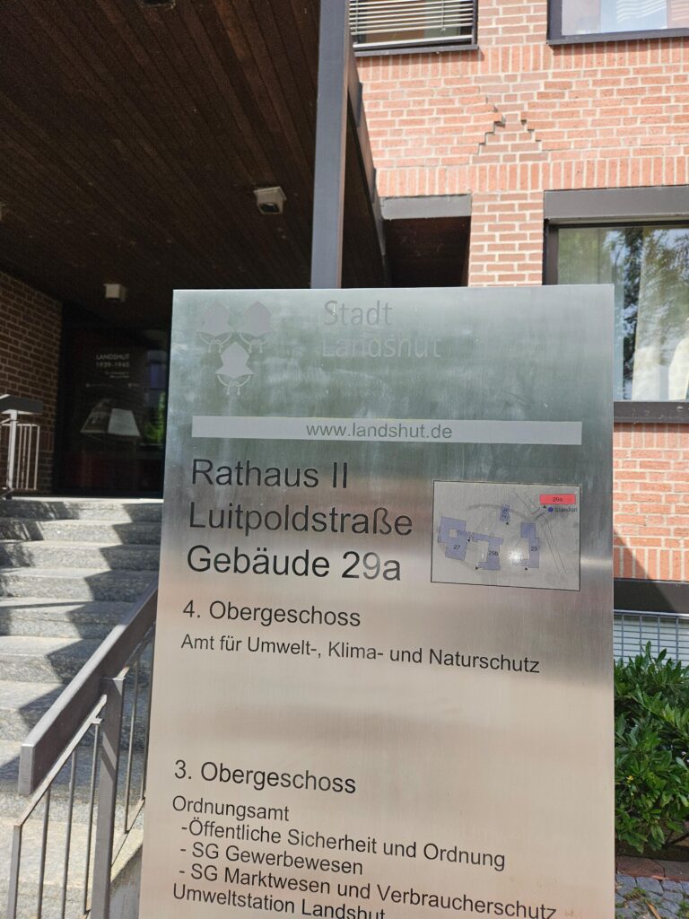 Das Schild vor dem Gebäude der Stadverwaltung. Es sind ein paar Etagen und Büros genannt. Nichts wichtiges.